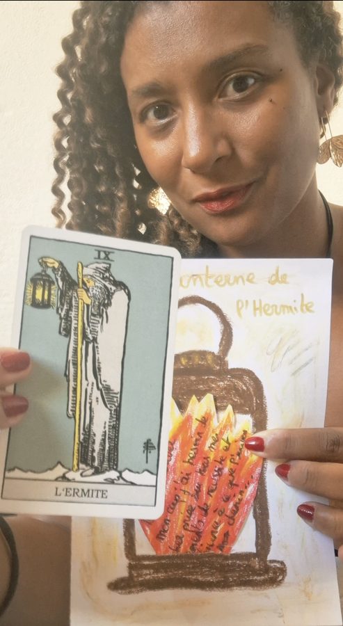 Johanna, tarologue et art-thérapeute, tient sa lanterne de L'Hermite dessinée à la main à côté de la carte L'Hermite du Tarot Rider-Waite